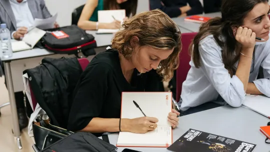 Student taking notes at EAE Business School